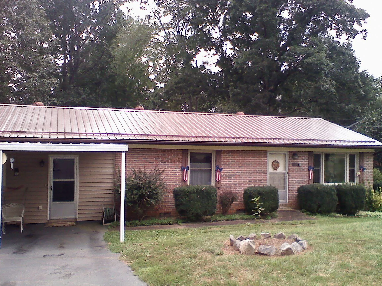 Bronze metal roof and carport on a brick ranch home — Roof Repair work by our crew in Wolcott