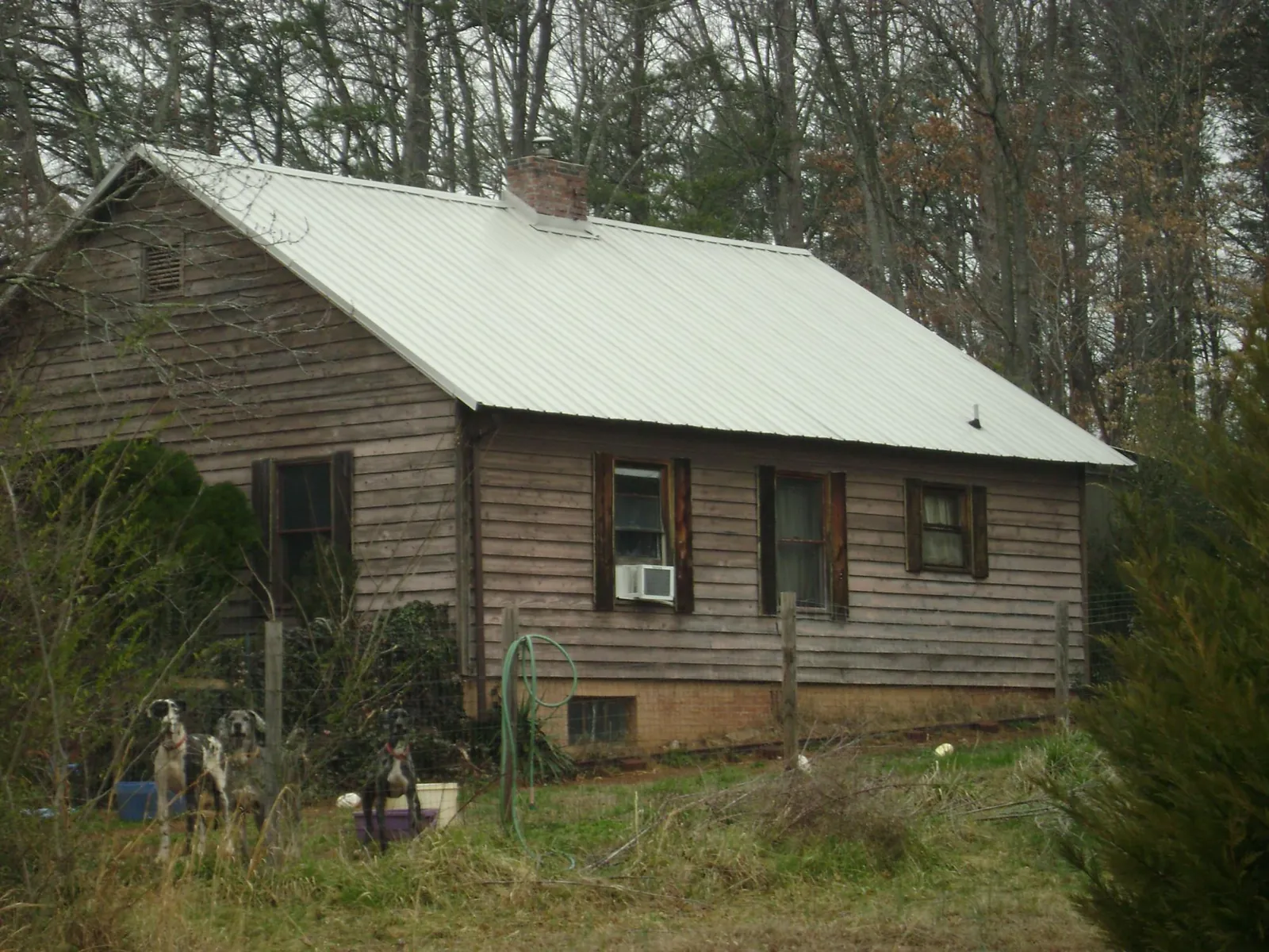 White metal roof on an old wood sided farmhouse, from a Metal Roof Installation job in Wolcott